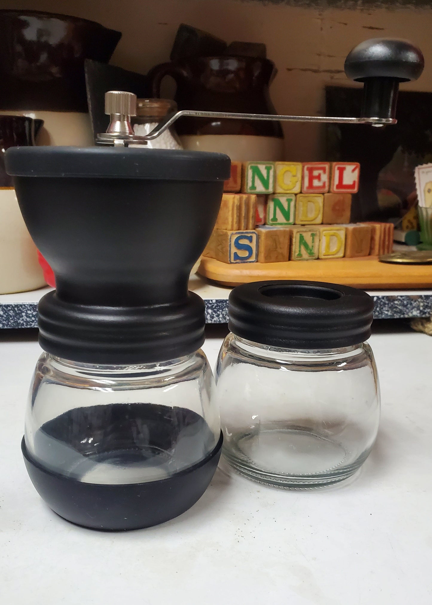 Two glass jars with black lids on a white surface