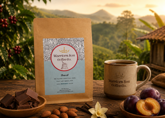 Warrior's Son Coffee Co. package with a mug, chocolate, nuts, and plums on a wooden table with a scenic background.